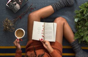 opened book on person's lap with gray socks