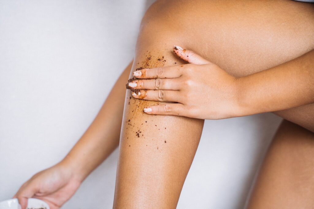 A Hand Applying Scrub on Her Leg