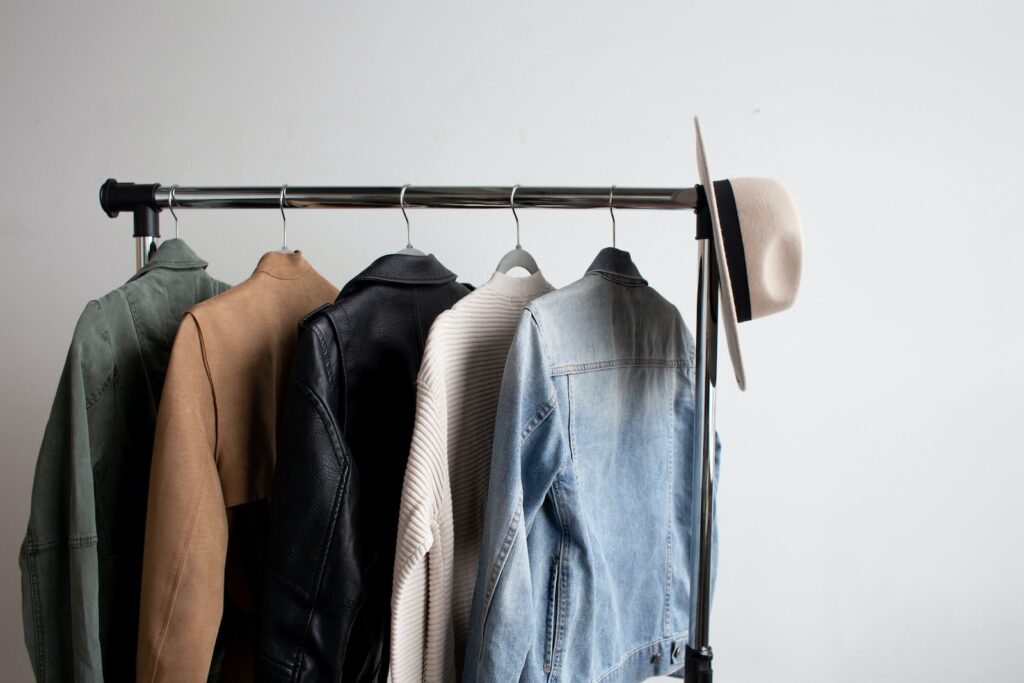 one cowboy hat and five jackets hanged on clothes rack