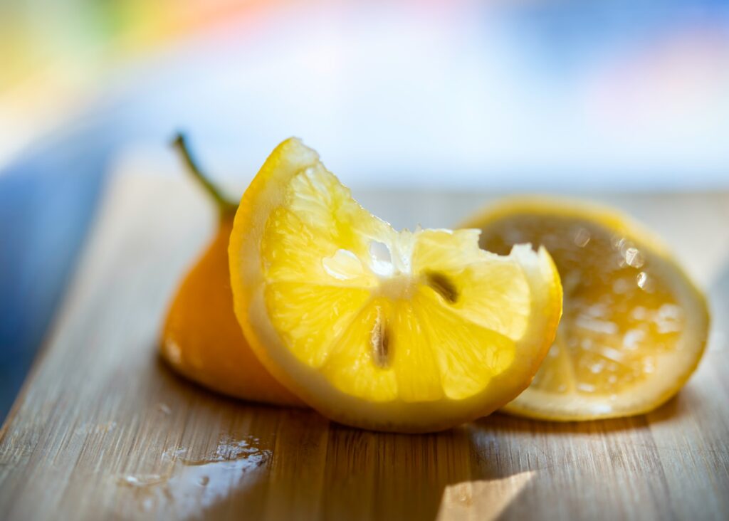 sliced lemon on brown wooden chopping board