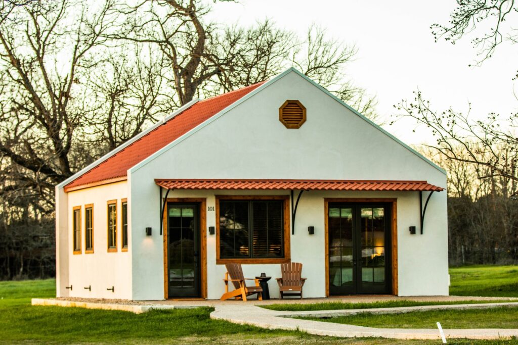 white and red concrete house near bare trees during daytime