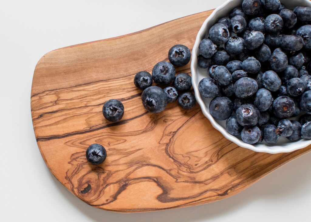 black berries on brown wooden chopping board