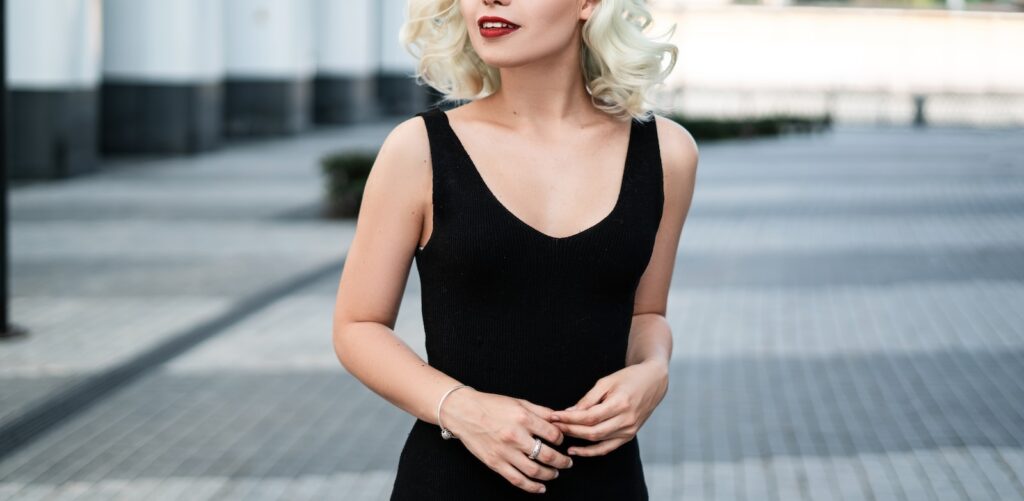 woman wearing black sleeveless top and black cap facing left