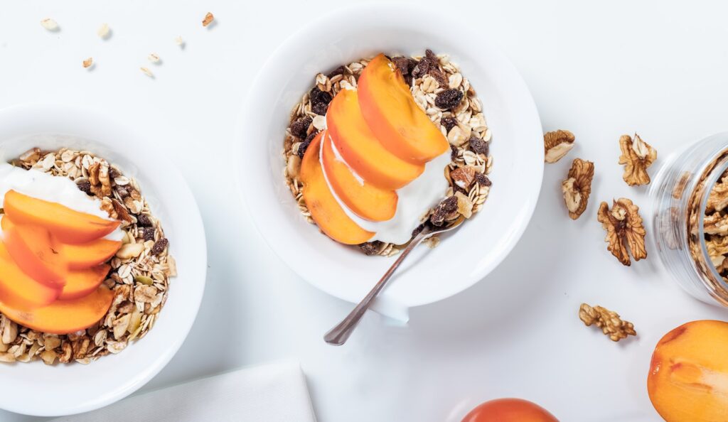 bowl of cereal with sliced fruits and spoon