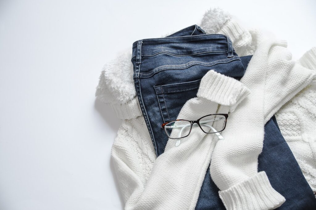 Black Framed Eyeglasses On White Jacket And Blue Denim Bottoms