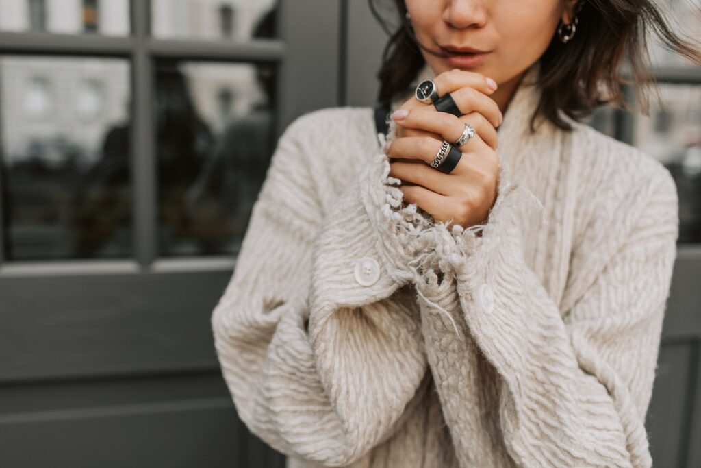 Woman in Beige Coat Wearing Silver and Black Rings