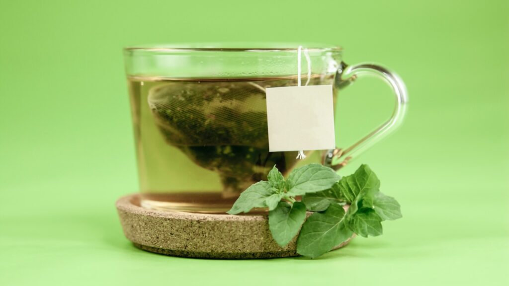 clear glass mug with green leaves