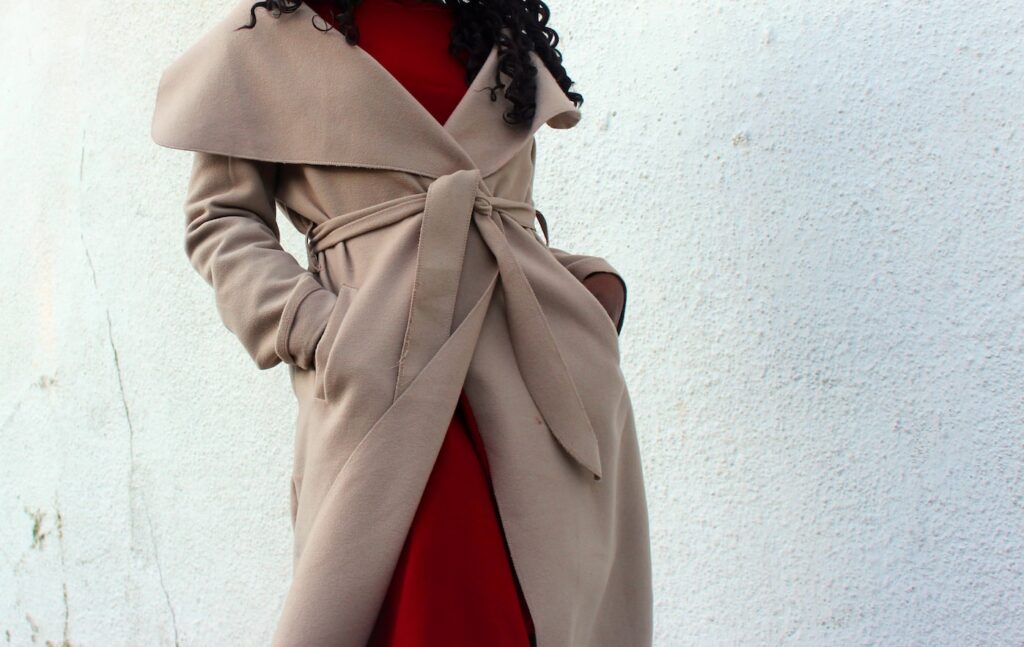 woman wearing brown coat with hands in her pockets