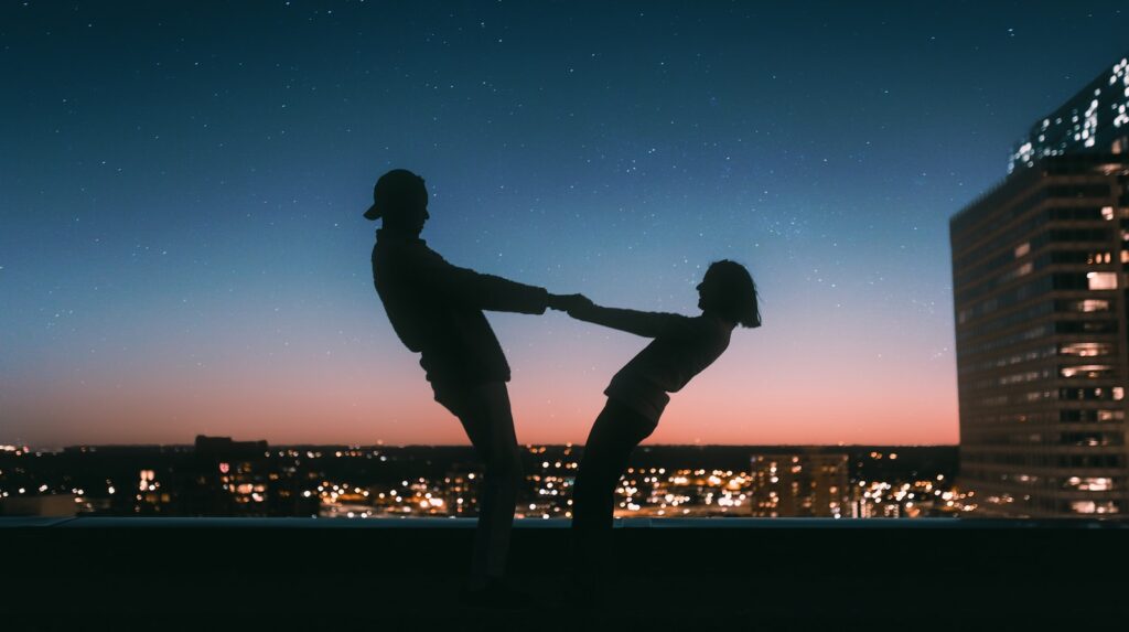 silhouette of man jumping on the field during night time