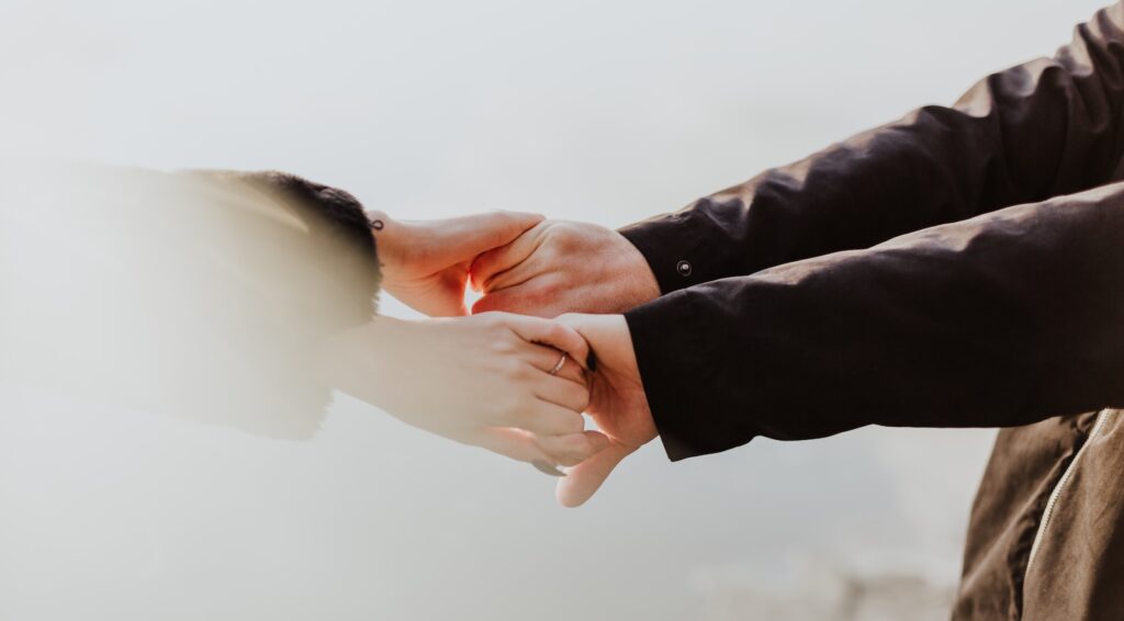 a couple holding hands while standing next to each other