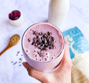 person holding cup of coffee with berries