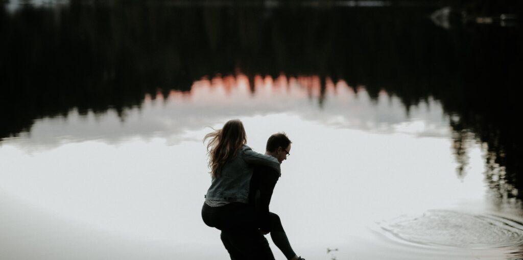 man carrying woman in his back