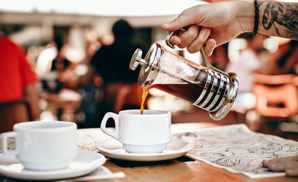 person pouring tea on white teacup