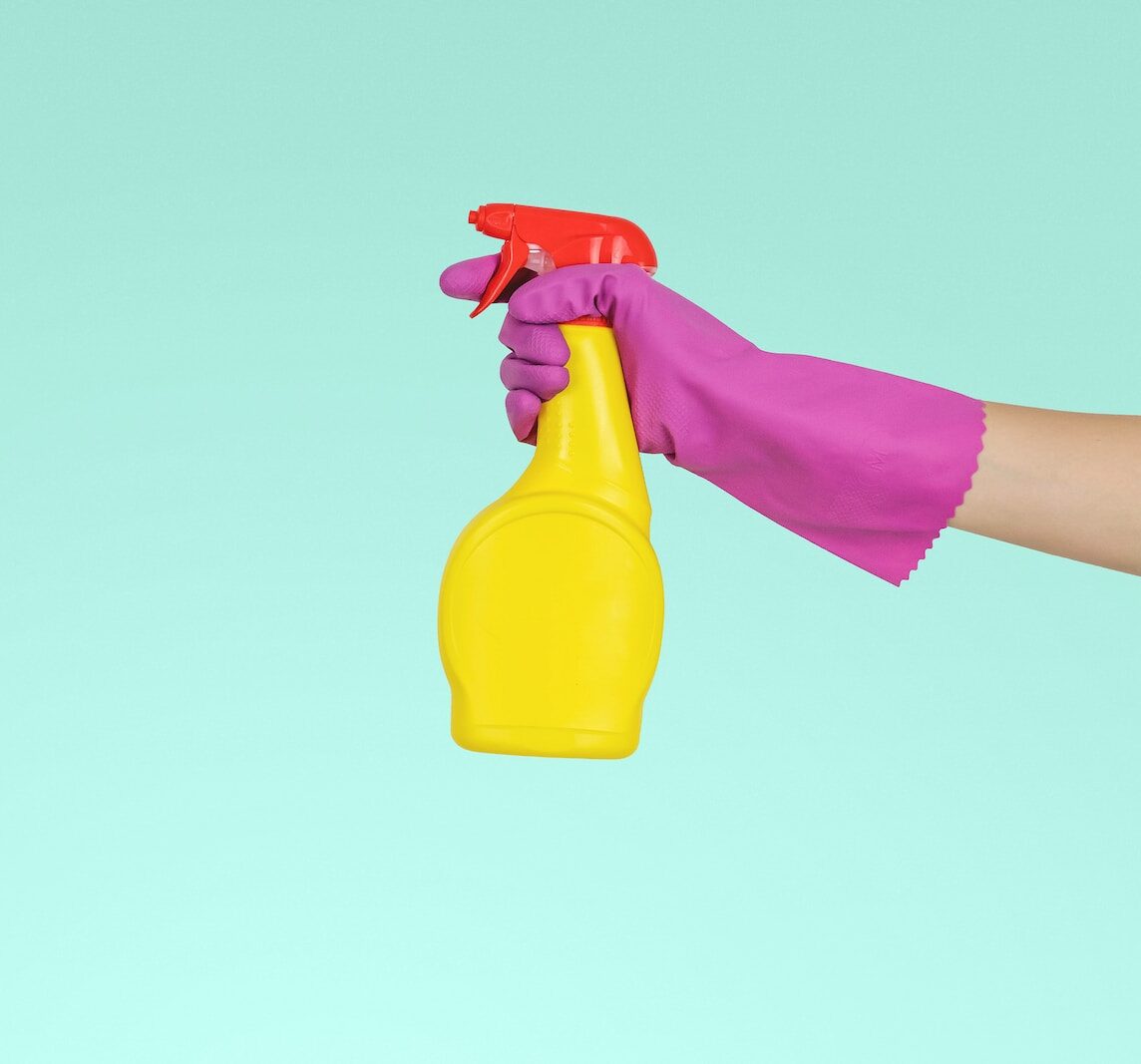 person holding yellow plastic spray bottle