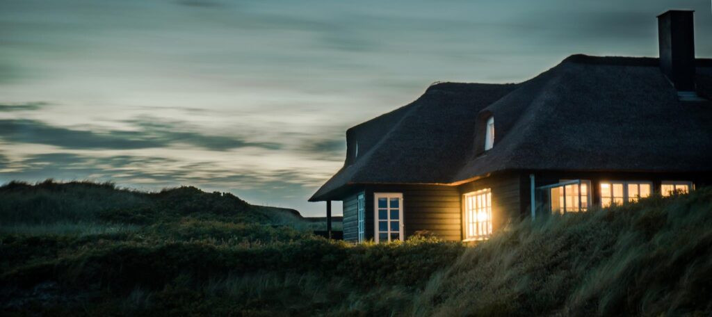 Gray House With Fireplace Surrounded by Grass Under White and Gray Cloudy Sky