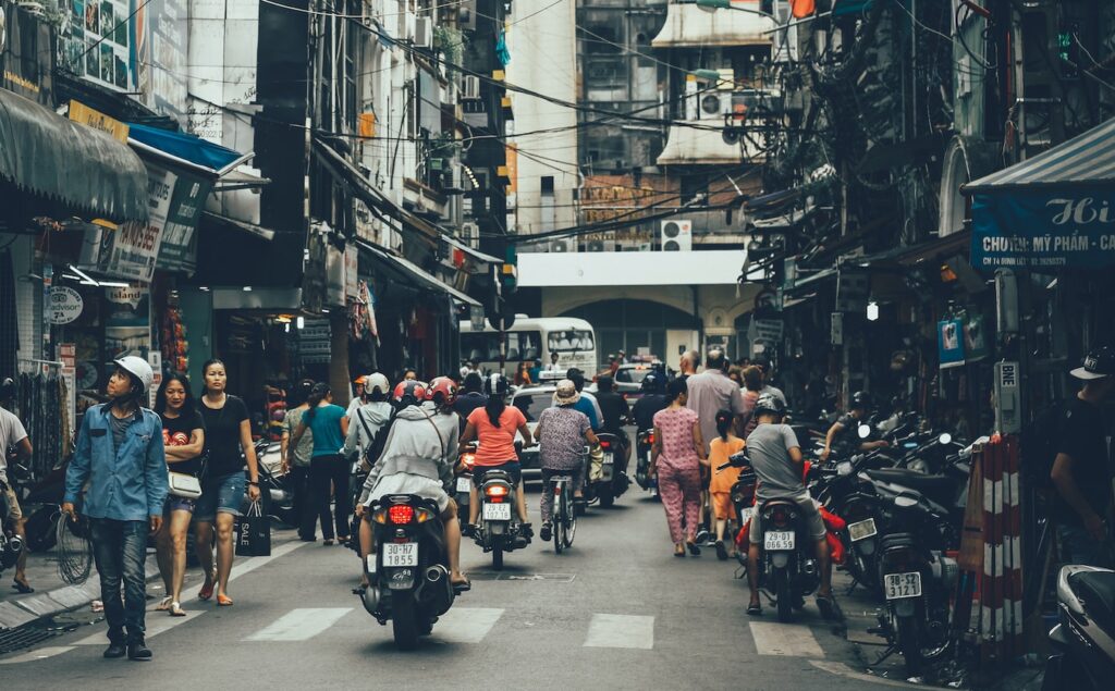 people walking on road between buildings