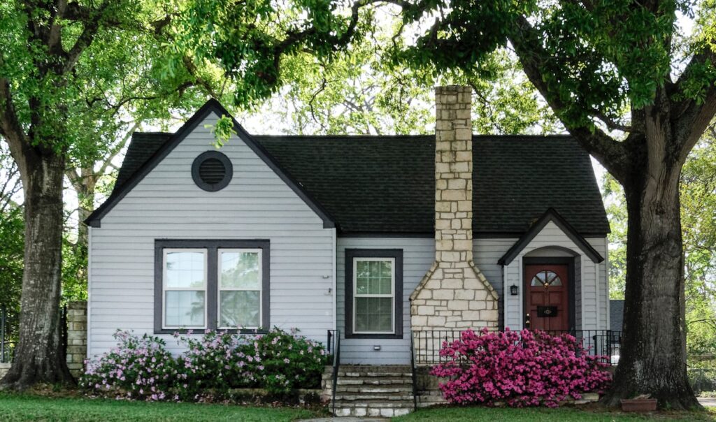 white and brown house surrounded by green trees