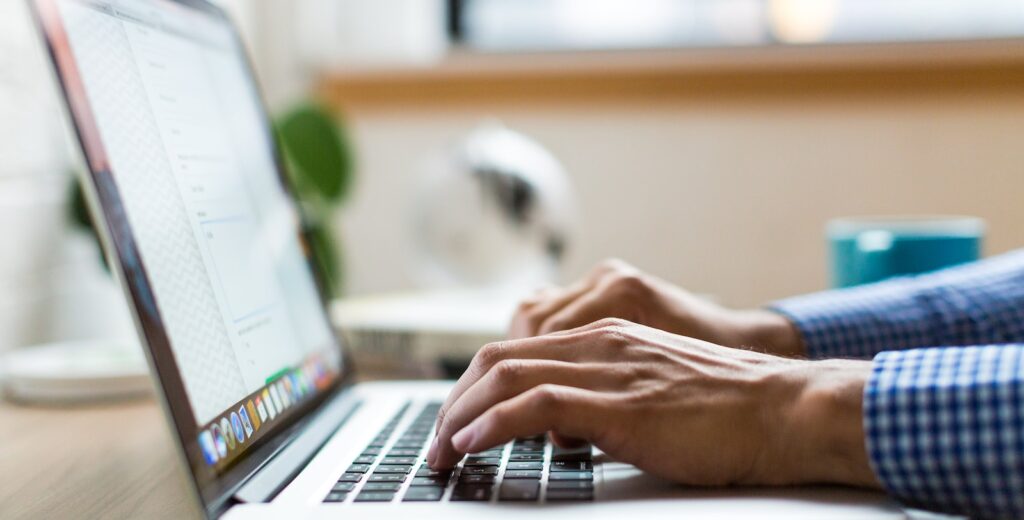 person typing on silver MacBook