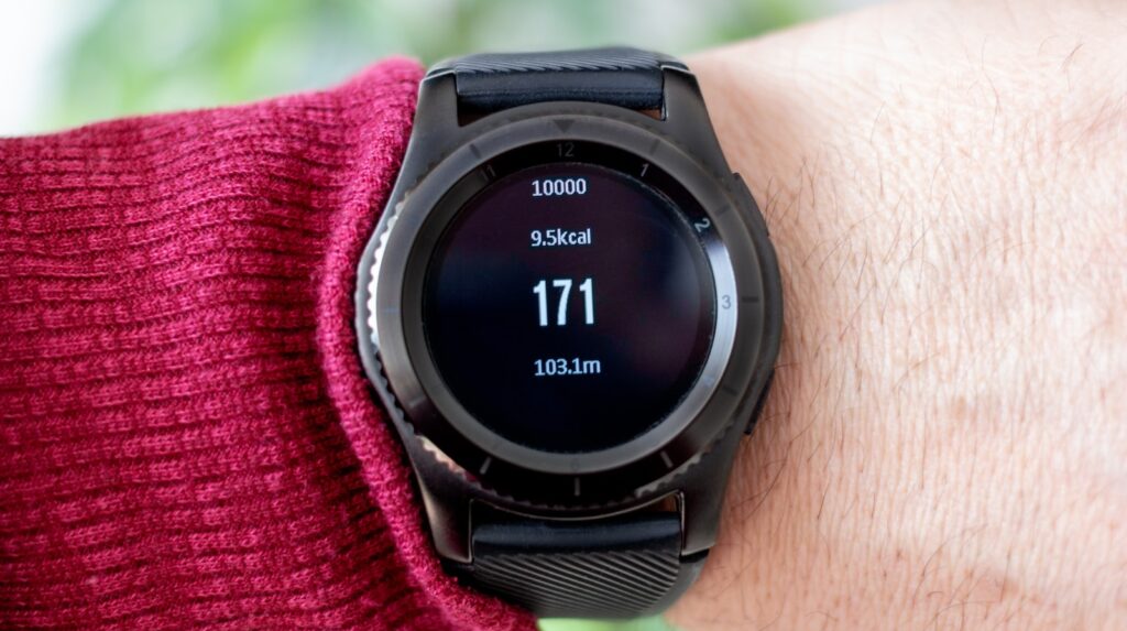 person wearing round black smartwatch