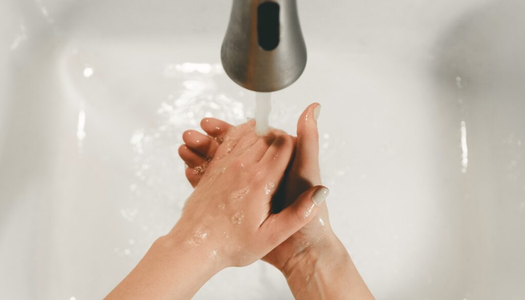 persons feet on white bathtub