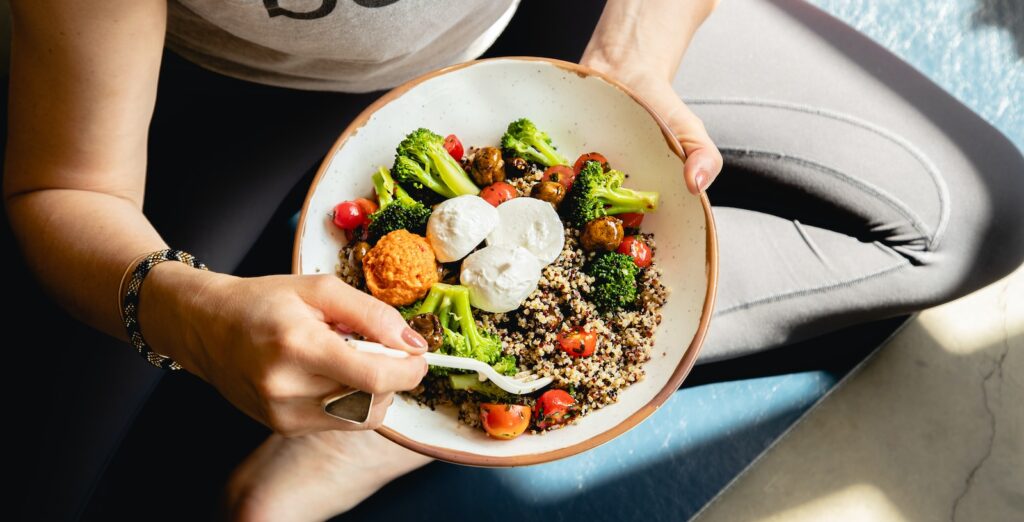 a woman is holding a bowl of food