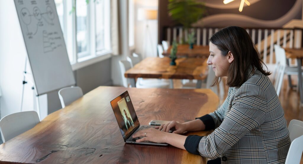 woman in gray and white striped long sleeve shirt using silver macbook