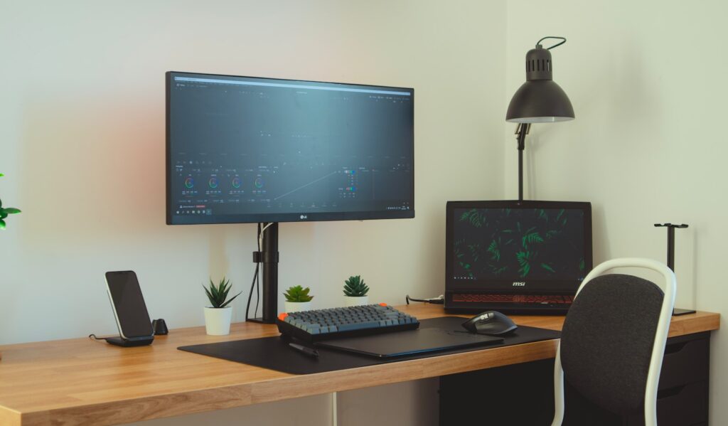 black flat screen computer monitor on brown wooden desk