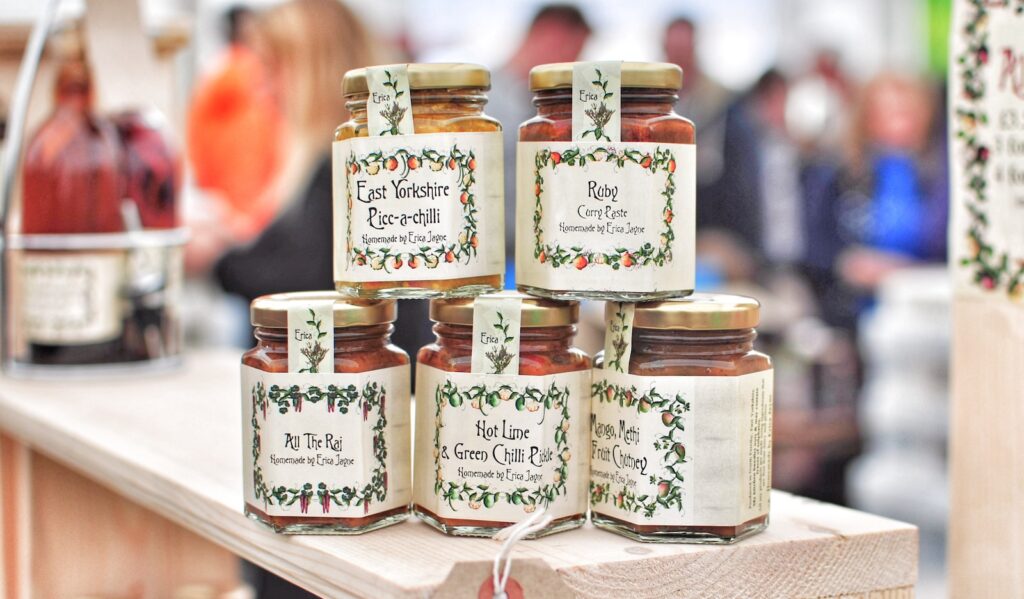 selective focus photo of five glass jars on brown wooden table