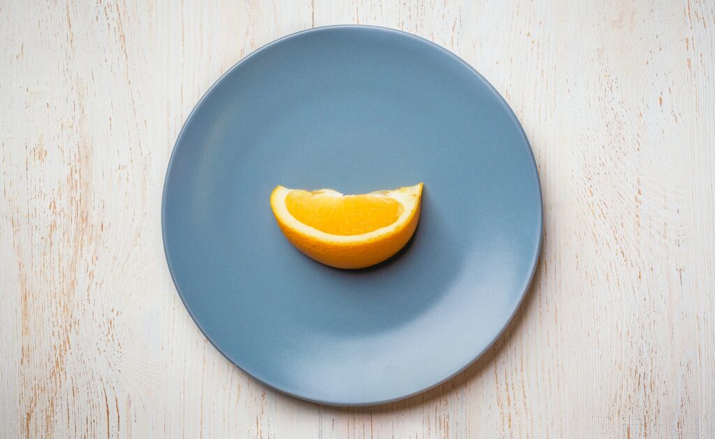 a blue plate with a half of an orange on it