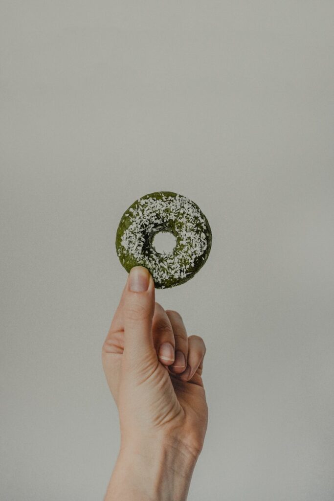 person holding green and black round ornament