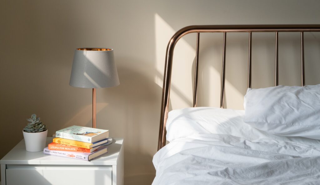 table lamp on white wooden nightstand beside bed