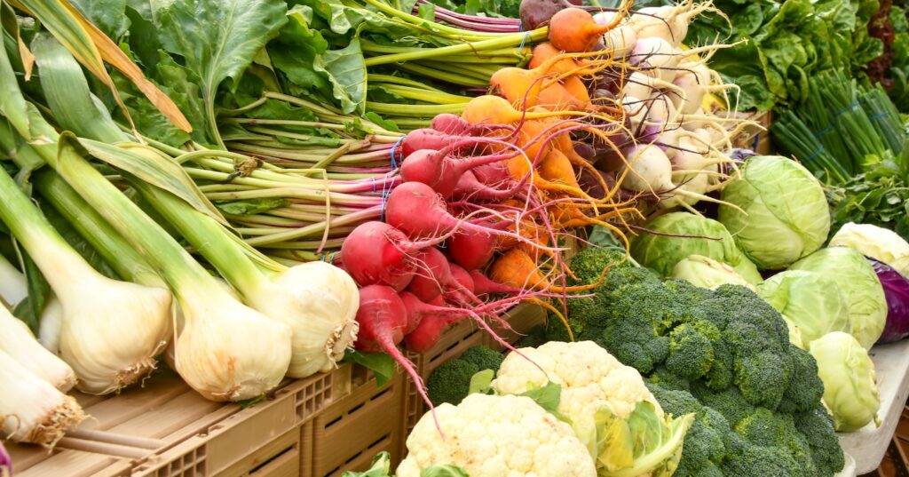 green and red vegetable on brown wooden table