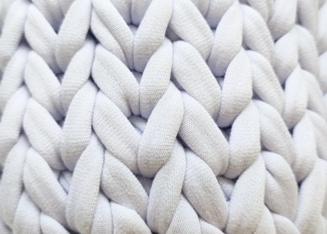 Diagonal chunky knit throw on sofa corner near a tall floor plant