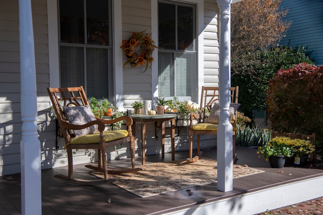 Alt text: cozy fall front porch decorated with blankets and pumpkins