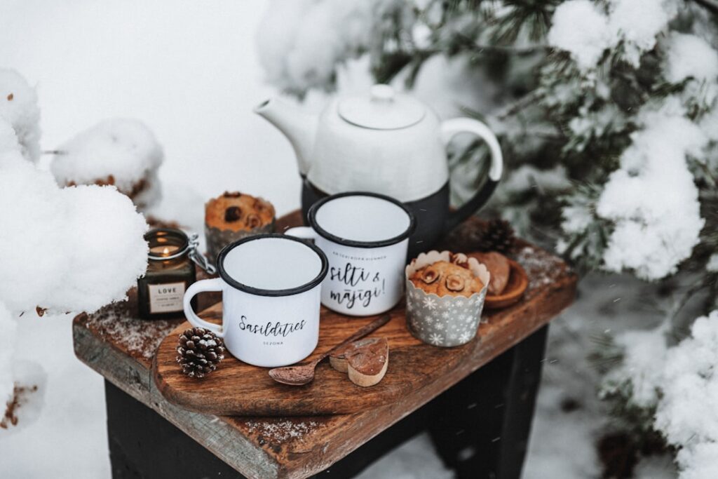 A cozy hygge coffee station on a wooden tray with ceramic mugs and a small plant