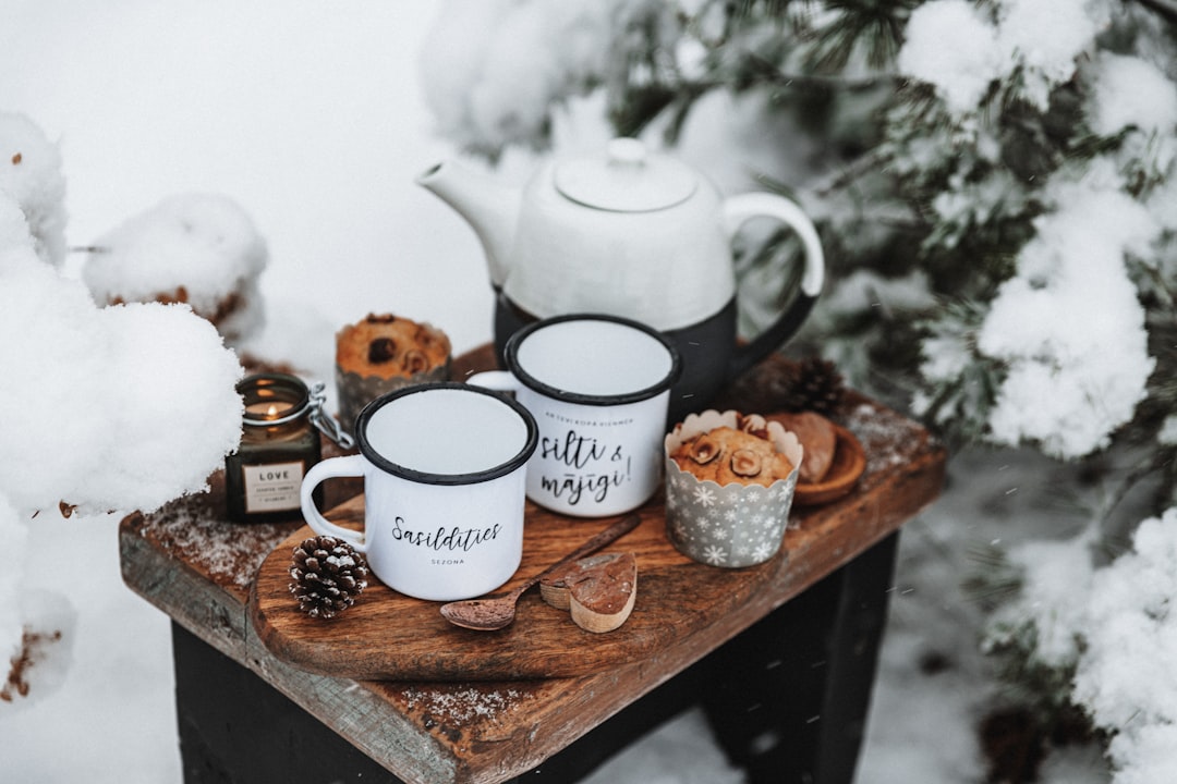 A cozy hygge coffee station on a wooden tray with ceramic mugs and a small plant