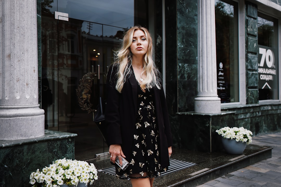Leather jacket layered over floral sundress with ankle boots as fall layering pieces