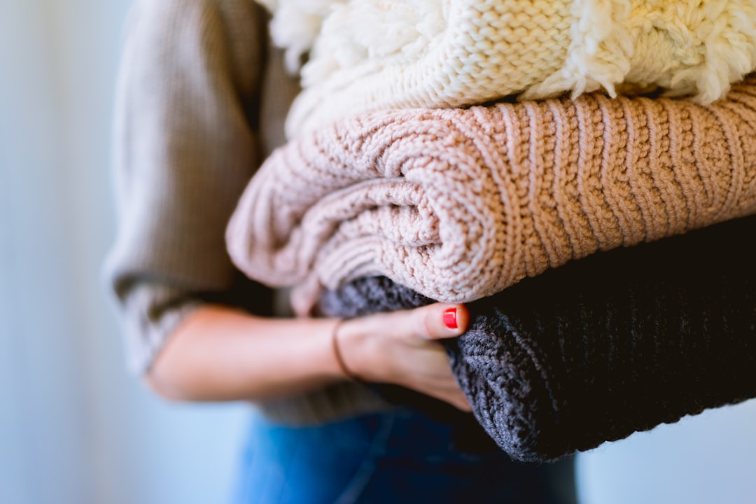 Person using a fabric shaver to remove pilling from chunky knit throw
