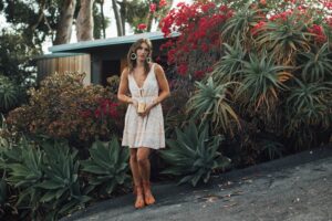 Sundress styled with chunky knits and boots for fall outfit transition