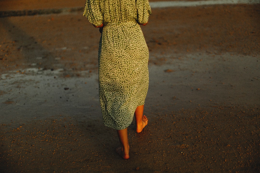Chunky knits paired with a floral maxi dress and brown leather ankle boots for autumn style