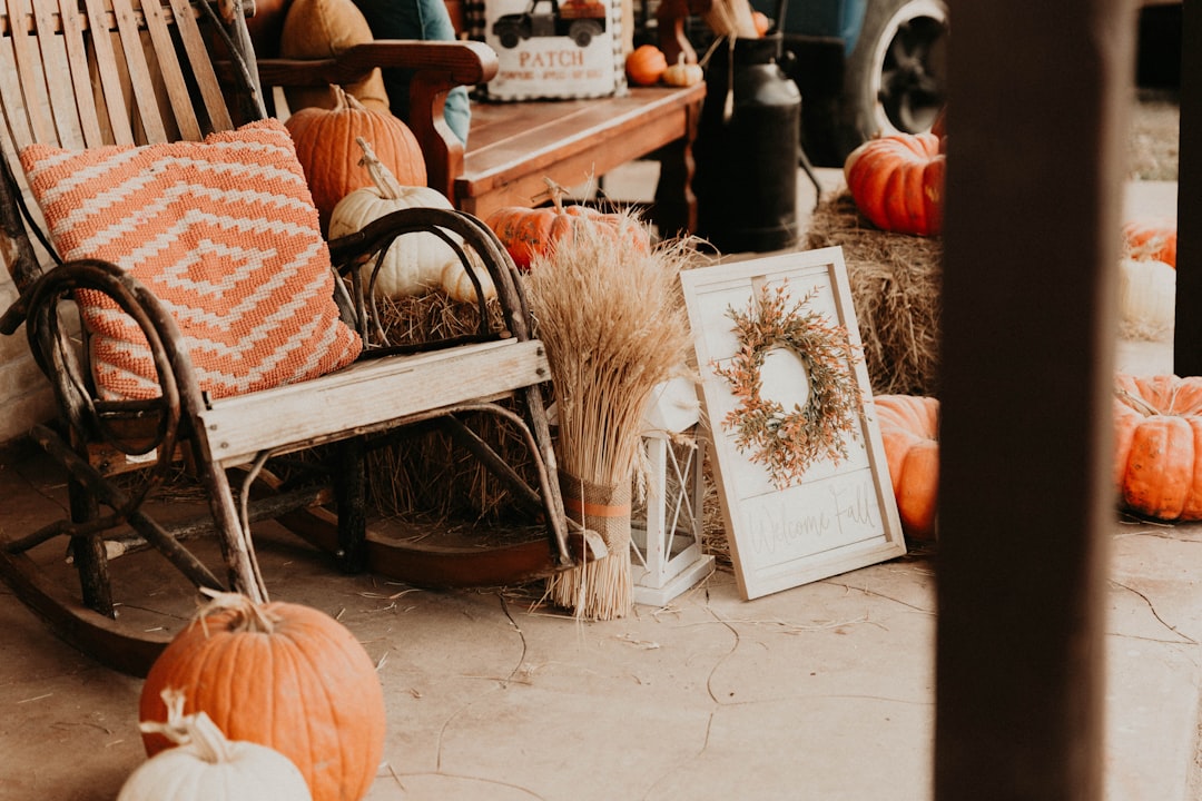 Alt text: thrifted throws draped over porch chairs with DIY candle lanterns