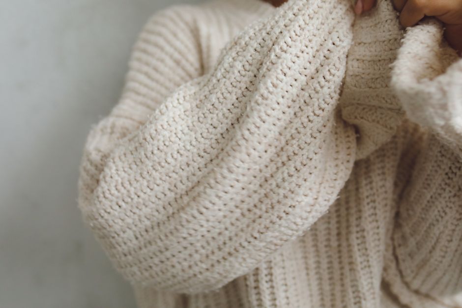 Tying a chunky knit sweater over a summer maxi dress for fall layering